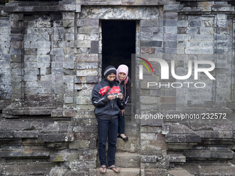 Couples inspect their digital camera after pose at a Temple in Complex Temple at Dieng. Dieng plateau in Central Java, is part of the distri...