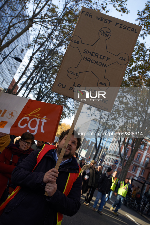 A man holds a placard reading 'The law of the wealthiest'. More than 4000 protesters took to the streets of Toulouse against the new Macron'...