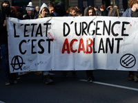 Anarchists hold a banner reading 'State of emergency : it's oppressive' (in french there is a pun between 'accablant' ie 'exhausting' and 'A...