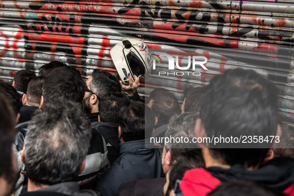 Protesters from the communist labour union PAME try to bring down the entrance of the Labour Ministry during a demonstration against changes...