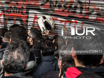 Protesters from the communist labour union PAME try to bring down the entrance of the Labour Ministry during a demonstration against changes...