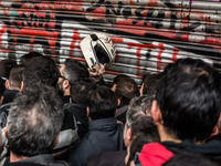 Protesters from the communist labour union PAME try to bring down the entrance of the Labour Ministry during a demonstration against changes...