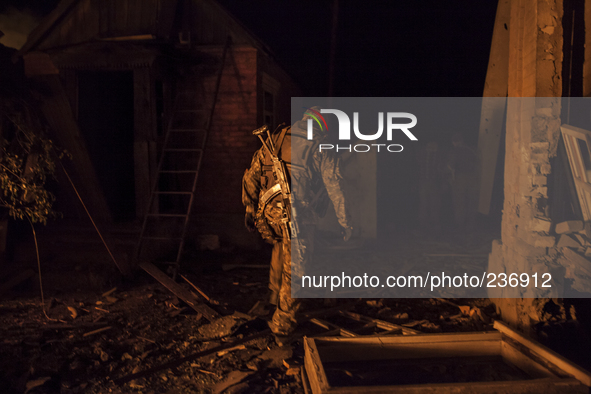 Pro-Russian paramilitary walks through the rubble of a bombed site 