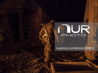 Pro-Russian paramilitary walks through the rubble of a bombed site (