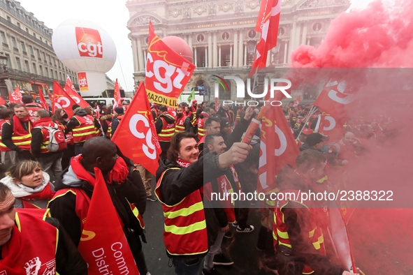 French General Confederation of Labour (CGT) unionists hold smoke canisters as they gather in front of Paris' Opera Garnier on December 20,...