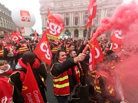 French General Confederation of Labour (CGT) unionists hold smoke canisters as they gather in front of Paris' Opera Garnier on December 20,...