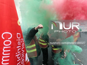 French General Confederation of Labour (CGT) unionists hold smoke canisters as they gather in front of Paris' Opera Garnier on December 20,...