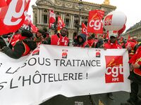 French General Confederation of Labour (CGT) unionists hold a banner reading "no to subcontracting in hotel industry" as they gather in fron...