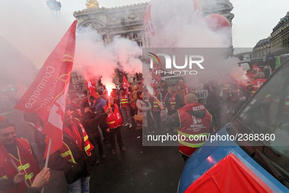 French General Confederation of Labour (CGT) unionists hold smoke canisters as they gather in front of Paris' Opera Garnier on December 20,...