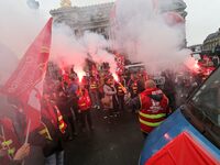 French General Confederation of Labour (CGT) unionists hold smoke canisters as they gather in front of Paris' Opera Garnier on December 20,...