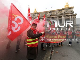 French General Confederation of Labour (CGT) unionists hold smoke canisters as they gather in front of Paris' Opera Garnier on December 20,...