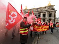 French General Confederation of Labour (CGT) unionists hold smoke canisters as they gather in front of Paris' Opera Garnier on December 20,...