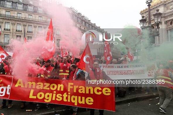 French General Confederation of Labour (CGT) unionists hold smoke canisters as they gather in front of Paris' Opera Garnier on December 20,...