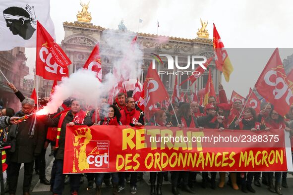 People hold a banner reading "withdrawal of Macron's executive orders" during a demonstration called by French General Confederation of Labo...