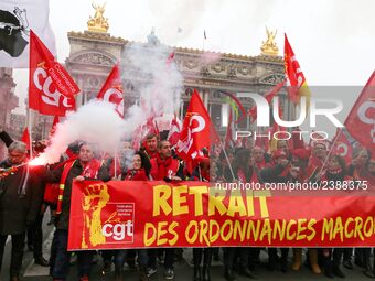 People hold a banner reading "withdrawal of Macron's executive orders" during a demonstration called by French General Confederation of Labo...