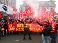 People hold a banner reading "withdrawal of Macron's executive orders" during a demonstration called by French General Confederation of Labo...