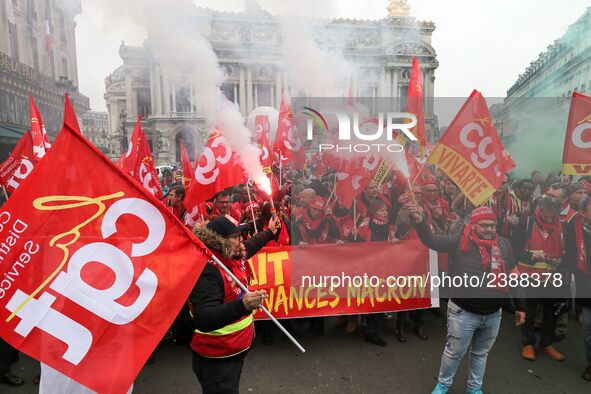 People hold a banner reading "withdrawal of Macron's executive orders" during a demonstration called by French General Confederation of Labo...