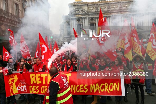 People hold a banner reading "withdrawal of Macron's executive orders" during a demonstration called by French General Confederation of Labo...