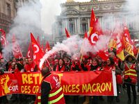 People hold a banner reading "withdrawal of Macron's executive orders" during a demonstration called by French General Confederation of Labo...