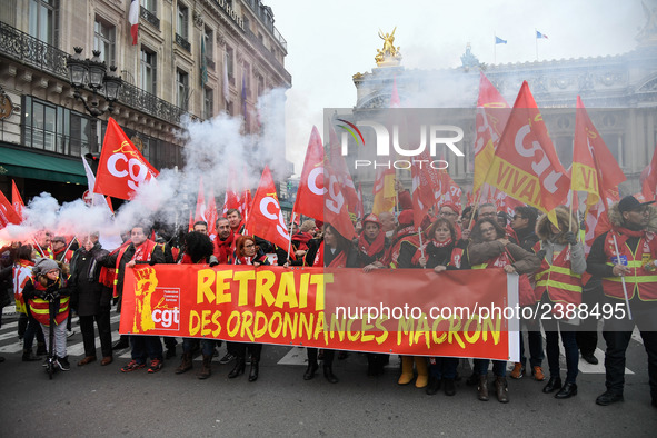 People hold a banner reading "withdrawal of Macron's executive orders" during a demonstration called by French General Confederation of Labo...