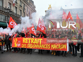 People hold a banner reading "withdrawal of Macron's executive orders" during a demonstration called by French General Confederation of Labo...