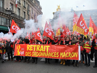 People hold a banner reading "withdrawal of Macron's executive orders" during a demonstration called by French General Confederation of Labo...