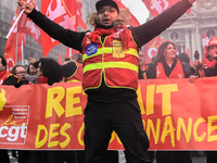 People hold a banner reading "withdrawal of Macron's executive orders" during a demonstration called by French General Confederation of Labo...