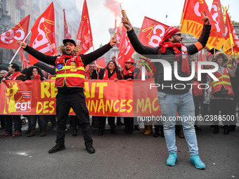 People hold a banner reading "withdrawal of Macron's executive orders" during a demonstration called by French General Confederation of Labo...