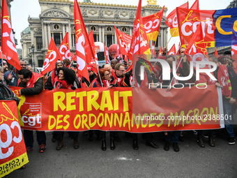 People hold a banner reading "withdrawal of Macron's executive orders" during a demonstration called by French General Confederation of Labo...