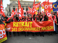 People hold a banner reading "withdrawal of Macron's executive orders" during a demonstration called by French General Confederation of Labo...