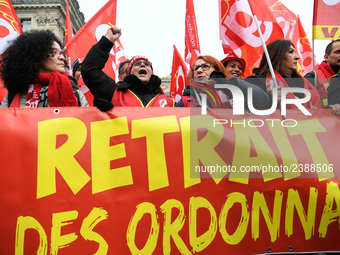 People hold a banner reading "withdrawal of Macron's executive orders" during a demonstration called by French General Confederation of Labo...