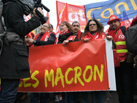 People hold a banner reading "withdrawal of Macron's executive orders" during a demonstration called by French General Confederation of Labo...