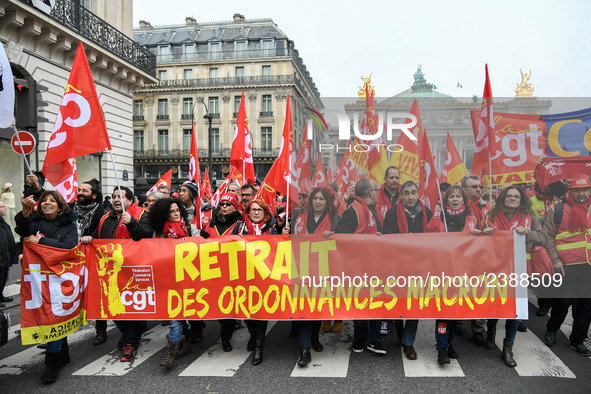 People hold a banner reading "withdrawal of Macron's executive orders" during a demonstration called by French General Confederation of Labo...