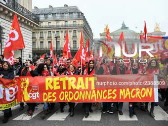 People hold a banner reading "withdrawal of Macron's executive orders" during a demonstration called by French General Confederation of Labo...