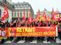 People hold a banner reading "withdrawal of Macron's executive orders" during a demonstration called by French General Confederation of Labo...