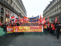 People hold a banner reading "withdrawal of Macron's executive orders" during a demonstration called by French General Confederation of Labo...