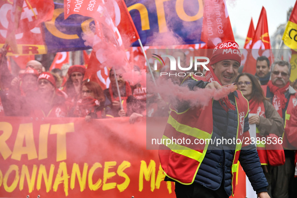 French General Confederation of Labour (CGT) unionists hold smoke canisters as they gather in front of Paris' Opera Garnier on December 20,...