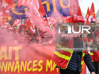 French General Confederation of Labour (CGT) unionists hold smoke canisters as they gather in front of Paris' Opera Garnier on December 20,...