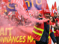 French General Confederation of Labour (CGT) unionists hold smoke canisters as they gather in front of Paris' Opera Garnier on December 20,...