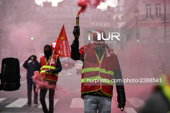 French General Confederation of Labour (CGT) unionists hold smoke canisters as they gather in front of Paris' Opera Garnier on December 20,...