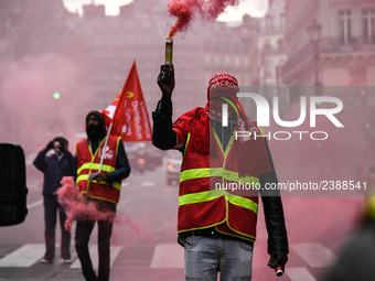 French General Confederation of Labour (CGT) unionists hold smoke canisters as they gather in front of Paris' Opera Garnier on December 20,...