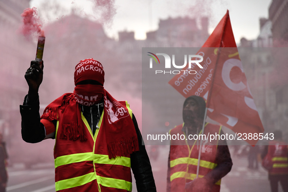 French General Confederation of Labour (CGT) unionists hold smoke canisters as they gather in front of Paris' Opera Garnier on December 20,...