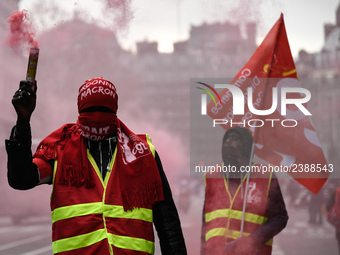 French General Confederation of Labour (CGT) unionists hold smoke canisters as they gather in front of Paris' Opera Garnier on December 20,...