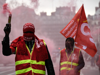 French General Confederation of Labour (CGT) unionists hold smoke canisters as they gather in front of Paris' Opera Garnier on December 20,...