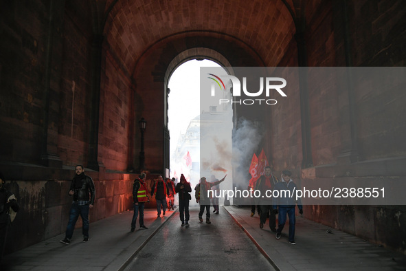 French General Confederation of Labour (CGT) unionists hold smoke canisters as they gather in front of Paris' Opera Garnier on December 20,...