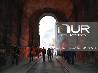 French General Confederation of Labour (CGT) unionists hold smoke canisters as they gather in front of Paris' Opera Garnier on December 20,...