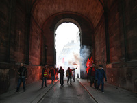 French General Confederation of Labour (CGT) unionists hold smoke canisters as they gather in front of Paris' Opera Garnier on December 20,...