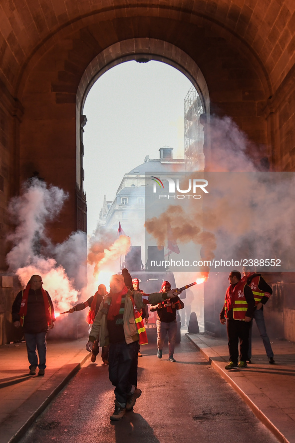 French General Confederation of Labour (CGT) unionists hold smoke canisters as they gather in front of Paris' Opera Garnier on December 20,...