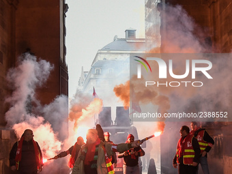 French General Confederation of Labour (CGT) unionists hold smoke canisters as they gather in front of Paris' Opera Garnier on December 20,...