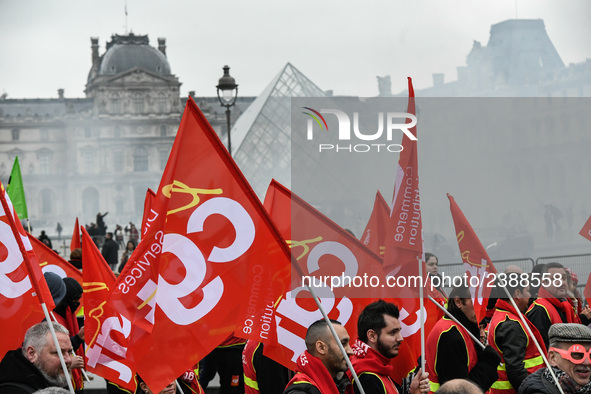 French General Confederation of Labour (CGT) unionists hold smoke canisters as they gather in front of Paris' Louvre Museum on December 20,...